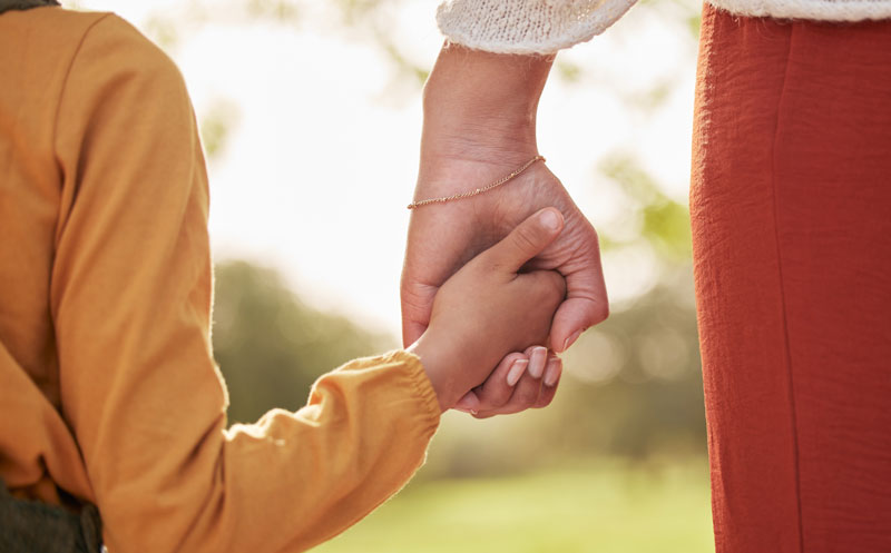 child holding hands with adult